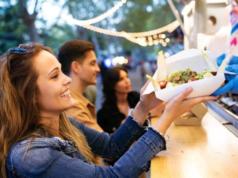 aufnahme-einer-gruppe-attraktiver-junger-freunde-die-verschiedene-arten-von-fast-food-auf-dem-essensmarkt-auf-der-strasse-auswaehlen-und-kaufen