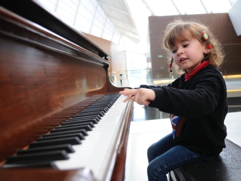 entzueckendes-kleines-maedchen-das-spass-hat-das-klavier-zu-spielen